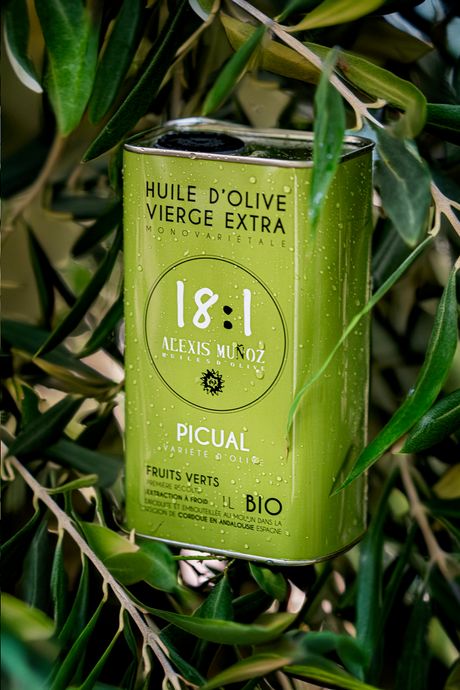1L bottle of olive oil, from the brand Alexis Muñoz, in a green color, on a background of olive branches.