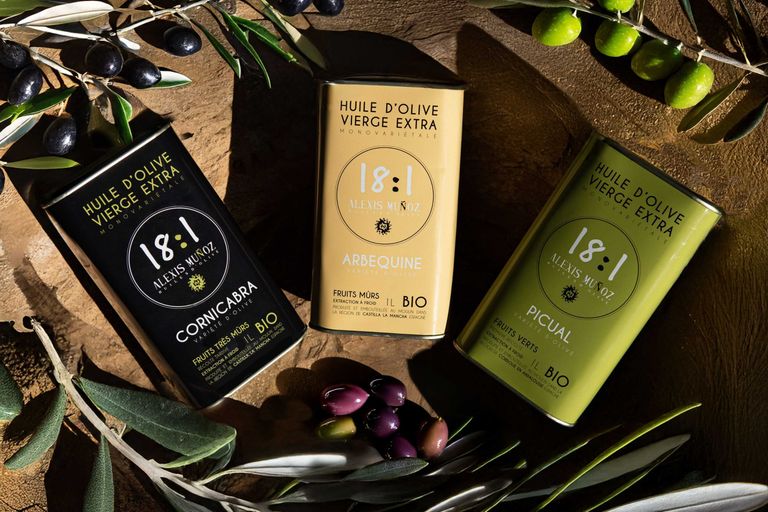 Three 1L olive oil cans in black, green, and beige colors, on a brown background.