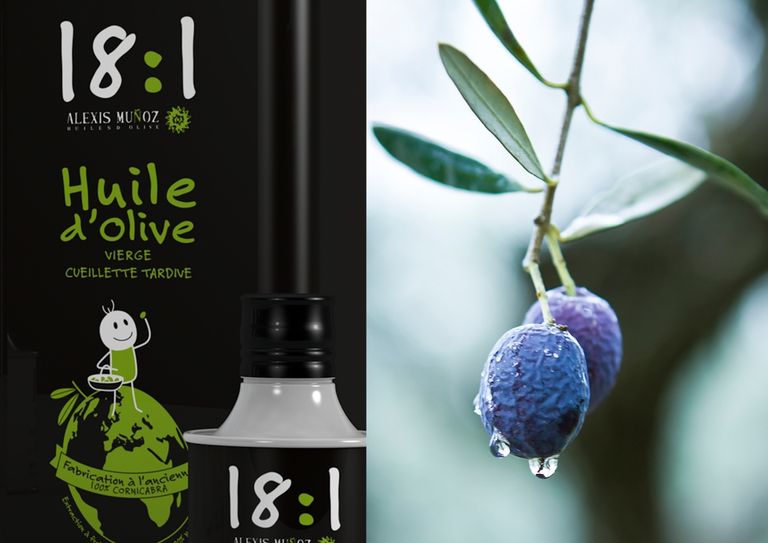 Black 18:1 olive oil can produced by Alexis Muñoz, featuring very ripe black olives still on the olive tree.
