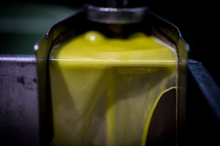 Huile d'olive de couleur jaune dorée, qui coule directement du moulin