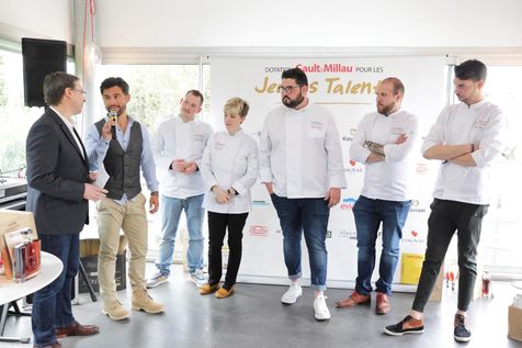 Photo de groupe avec 5 jeunes chefs et Alexis Muñoz au micro.