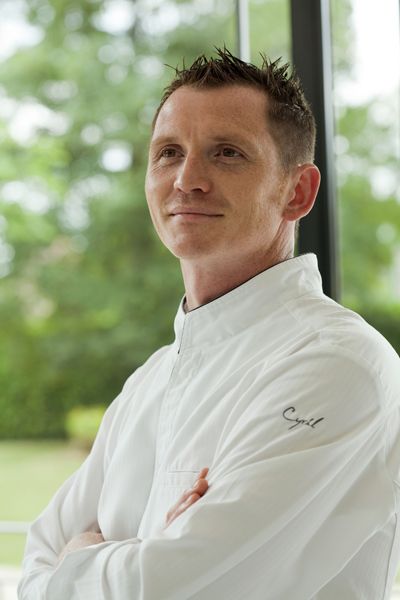 Chef Cyril Harberland en train de sourire et de croiser les bras.