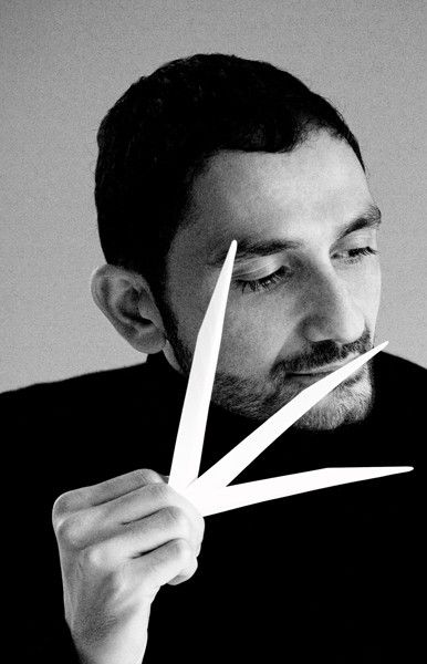 Photo en noir et blanc, du Nez et parfumeur  français d'origine arménienne Francis Kurkdjian en train de sentir des fragrances.