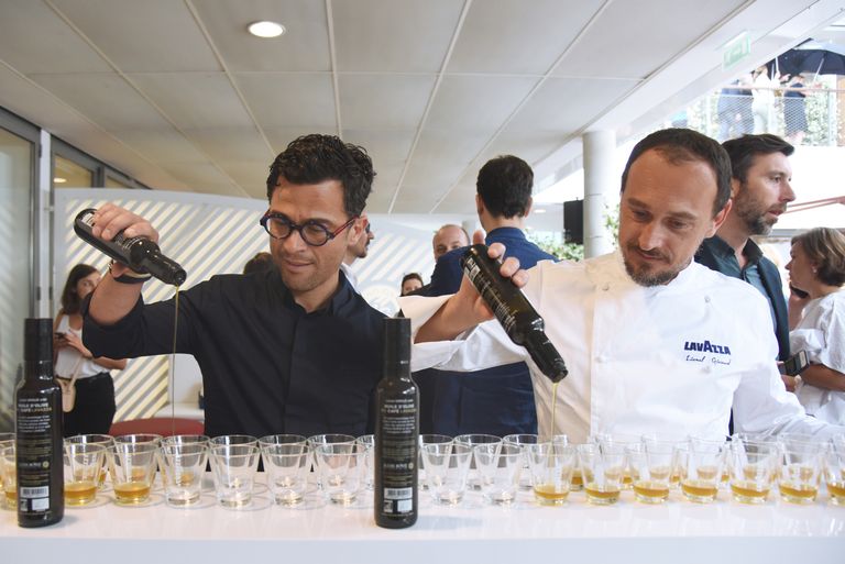 Alexis Muñoz, the olive oil producer, and Lionel Giraud, a two-Michelin-starred chef, pouring olive oil and Lavazza coffee into tasting cups during the launch event for this unexpected product.