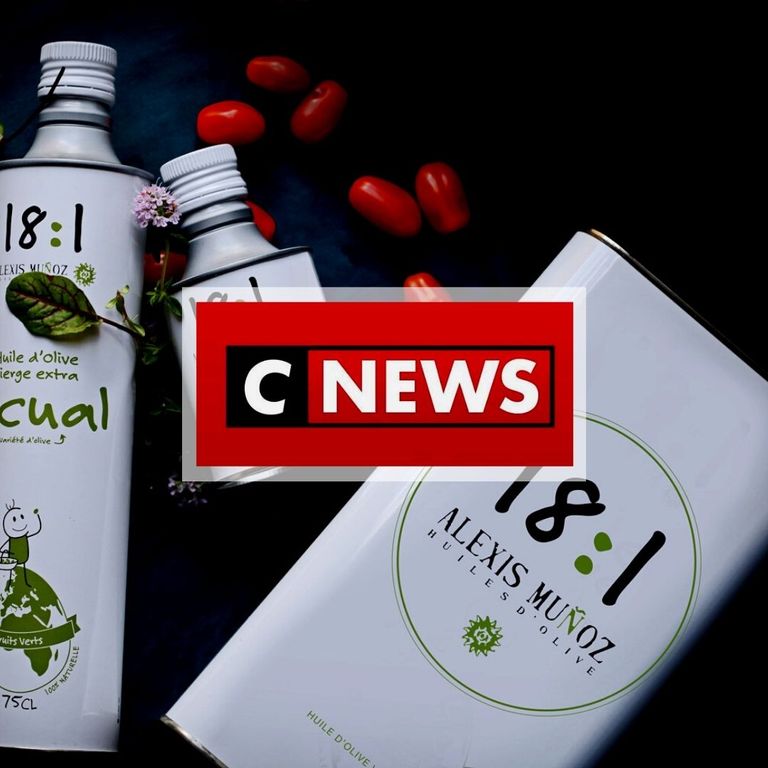 Atmospheric photo featuring tomatoes and purple flowers, showcasing square and cylindrical white tins of 18:1 Alexis Muñoz olive oil, with the CNEWS logo.