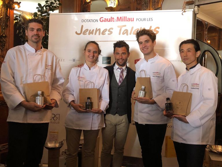 Group photo featuring four chefs with Alexis Muñoz in the center. Each chef is holding a 250ml white or black cylindrical can of 18:1 olive oil by Alexis Muñoz.