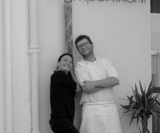 photo en noir et blanc de Fabian & Sarah Feldmann les bras croisés, souriants.