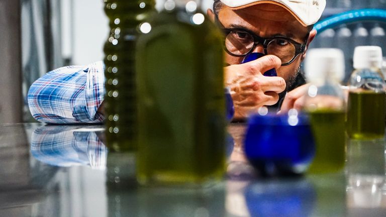 Close-up of producer Alexis Muñoz tasting olive oil at the mill.