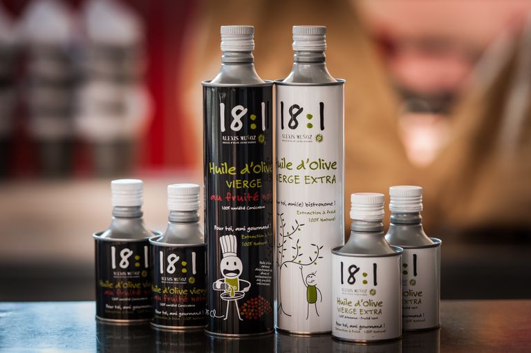 Cylindrical metal cans of monovarietal olive oil, Picual and Cornicabra, from the Alexis Muñoz brand.